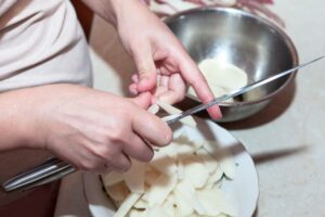 Someone cutting potatoes